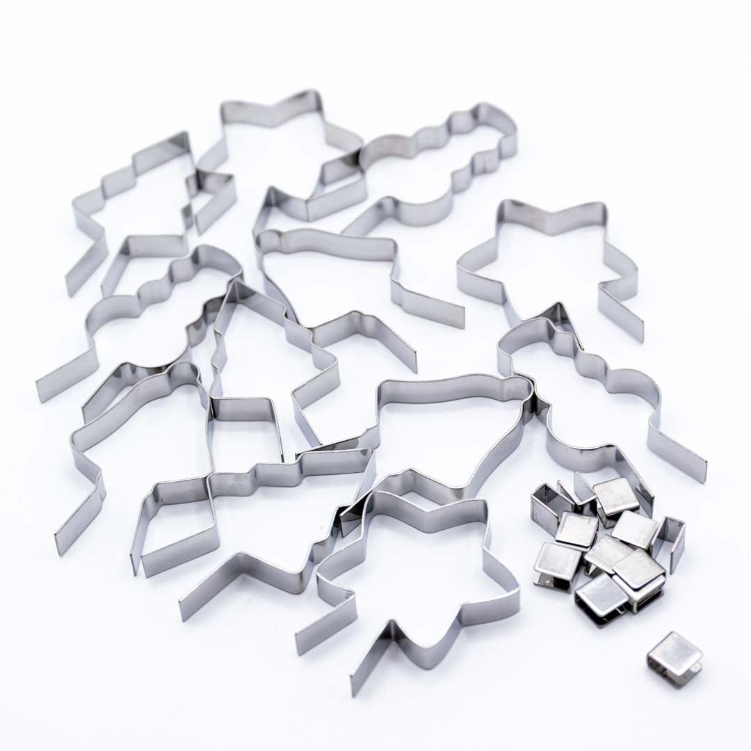 Set of metal lollipop molds shaped like stars and trees on a white background