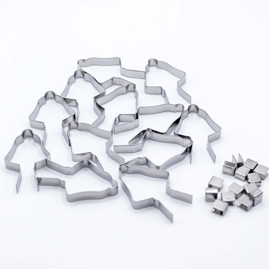 Set of metal Christmas bell shaped lollipop molds on a white background