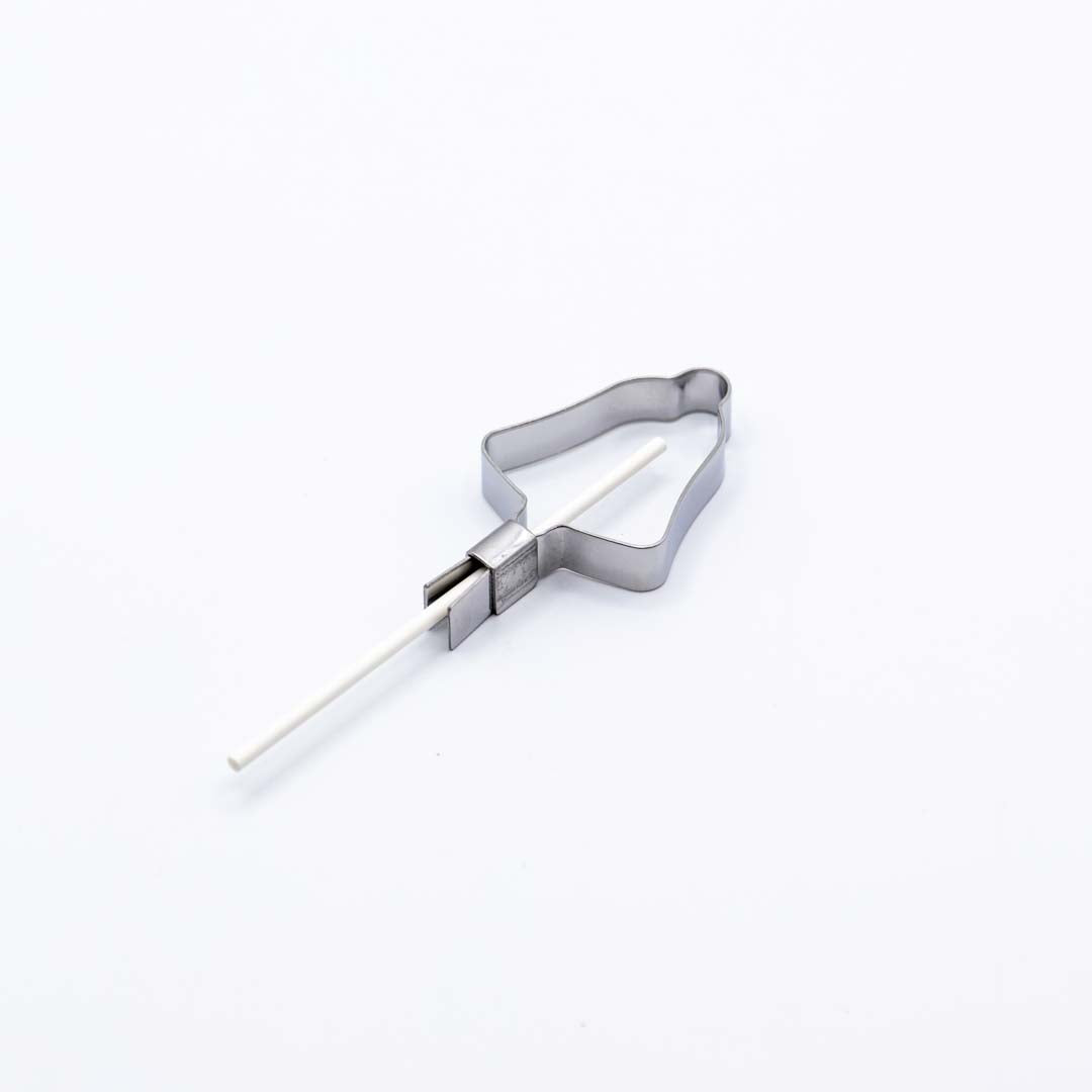 Metallic Christmas bell shaped lollipop mold on a white background